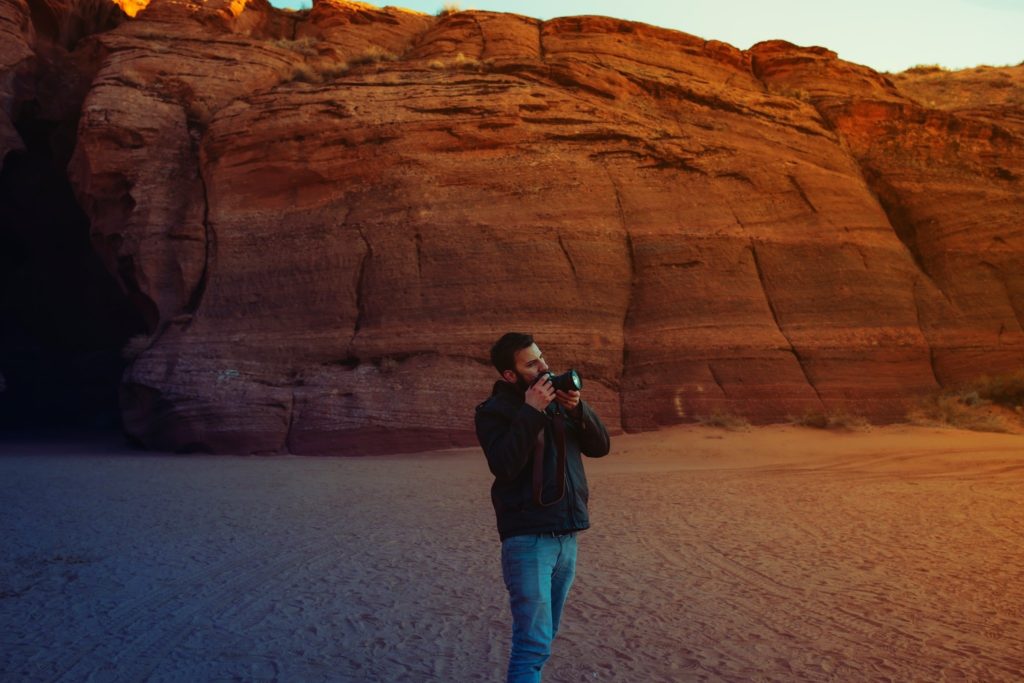 man in 30s in desert with camera