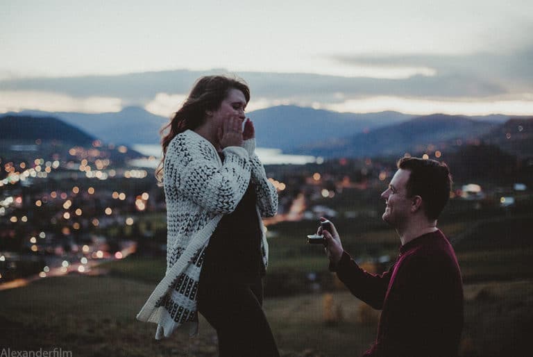 woman in shock as man proposes to her on one knee