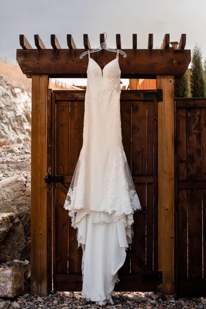 a wedding dress hanging off a fence