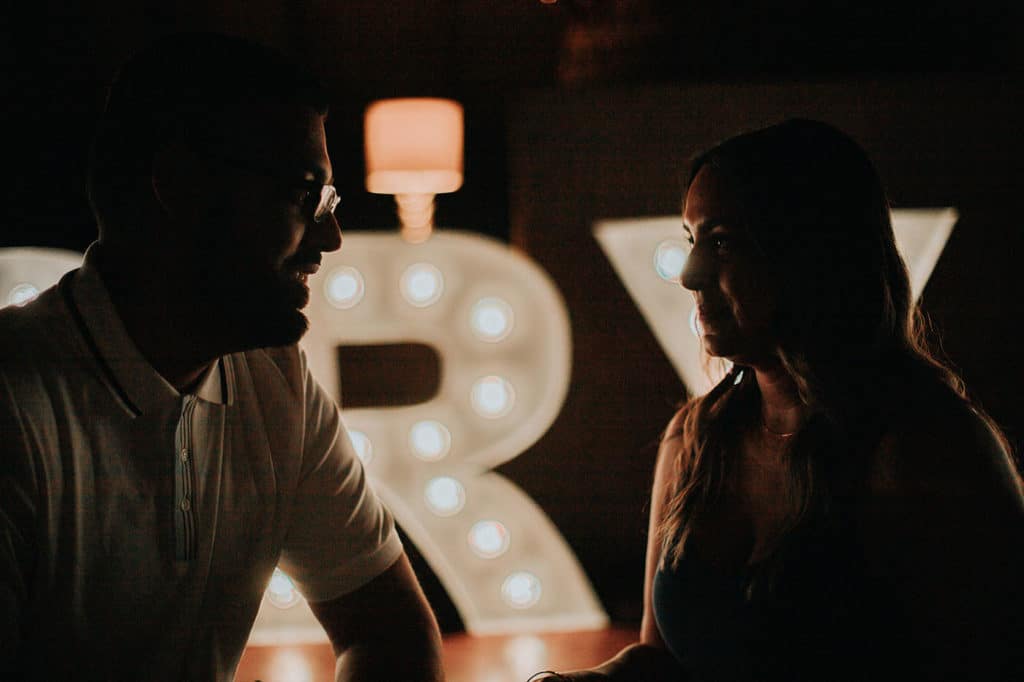 woman and man looking at each other in dimly lit room