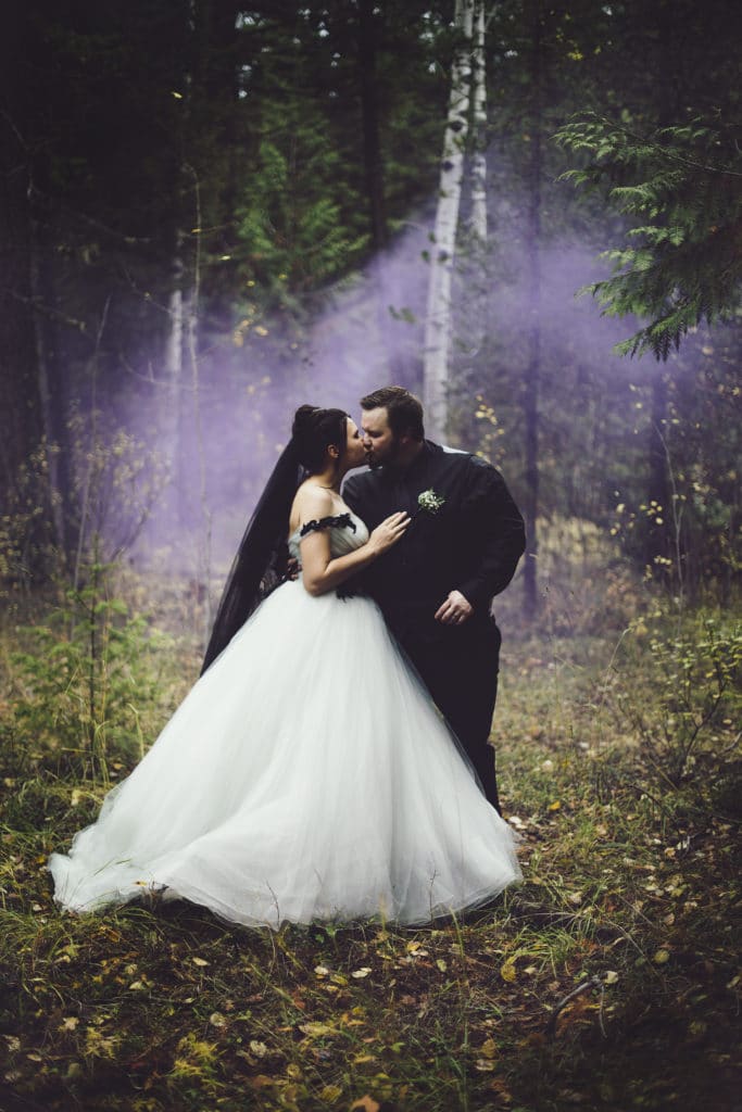 couple kissing with purple smoke behind them