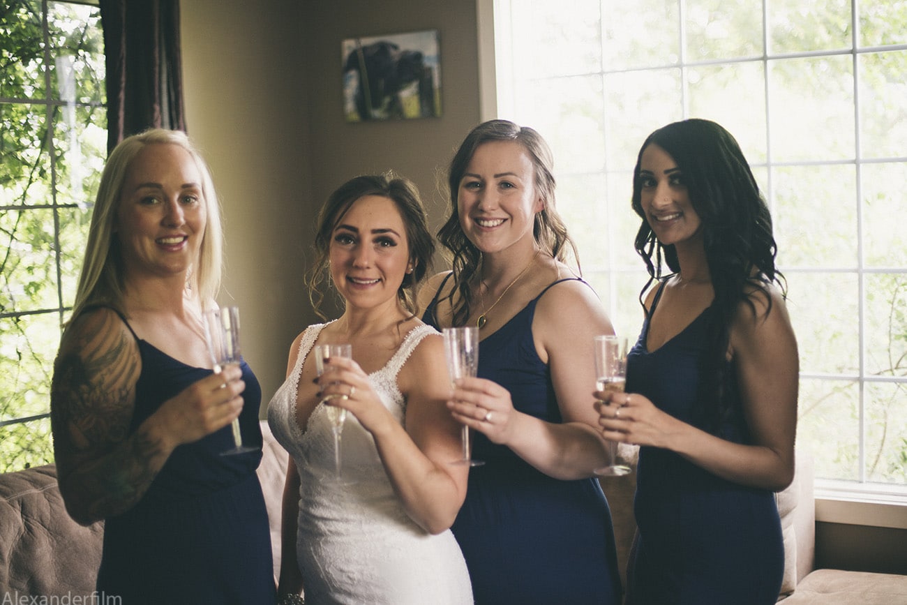 a bride and her bridesmaids all standing close to each-other