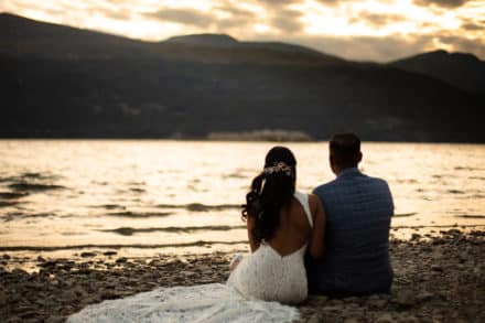 couple looking out at lake together during sunset