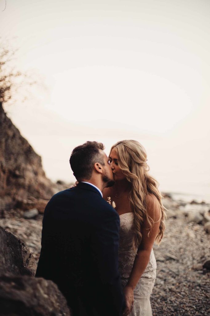couple kissing by the rocks on a beach