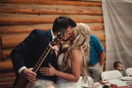 man holding a guitar and kissing bride