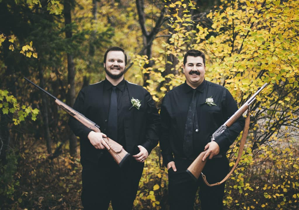 groomsman and best man both holding guns