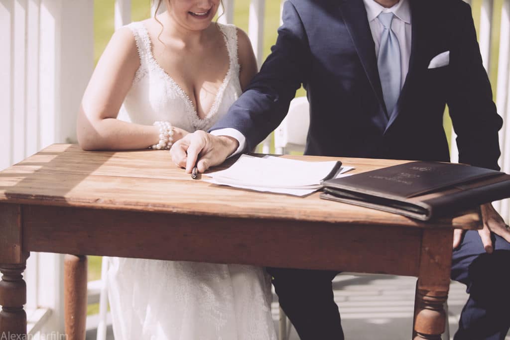 newly married couple signing papers