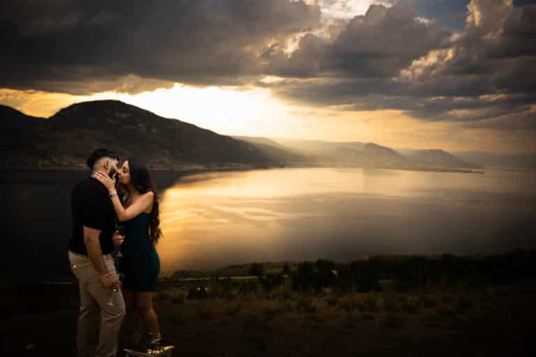 couple kissing in front of lake sunset